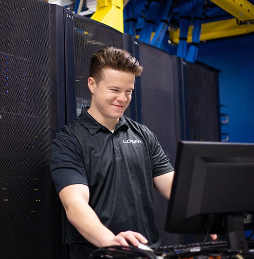 Login worker on a computer setting up colocation service for a business. 